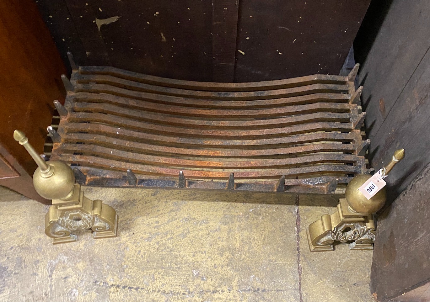 A cast iron rectangular fire grate, width 90cm, depth 42cm together with a pair of Dutch style brass dogs